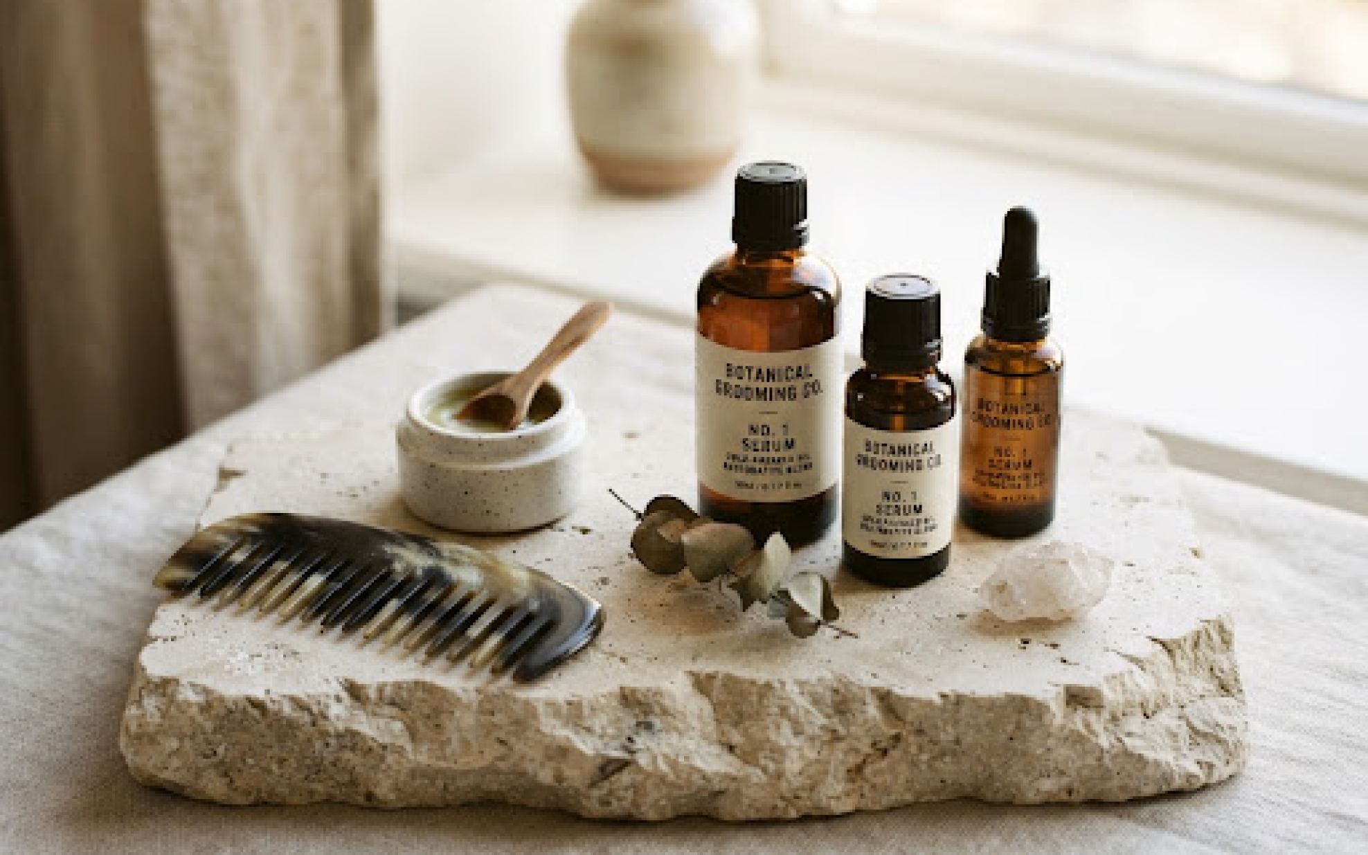 Amber botanical grooming bottles on raw limestone